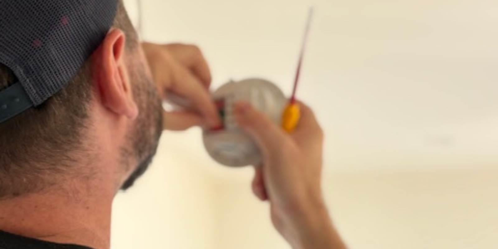 Electrician installing a ceiling fitting
